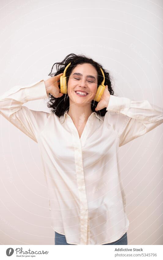Glückliche Frau mit Kopfhörern beim Musikhören zuhören Headset Porträt Apparatur heiter Lächeln Augen geschlossen Drahtlos Gerät Klang Gesang jung Audio Melodie