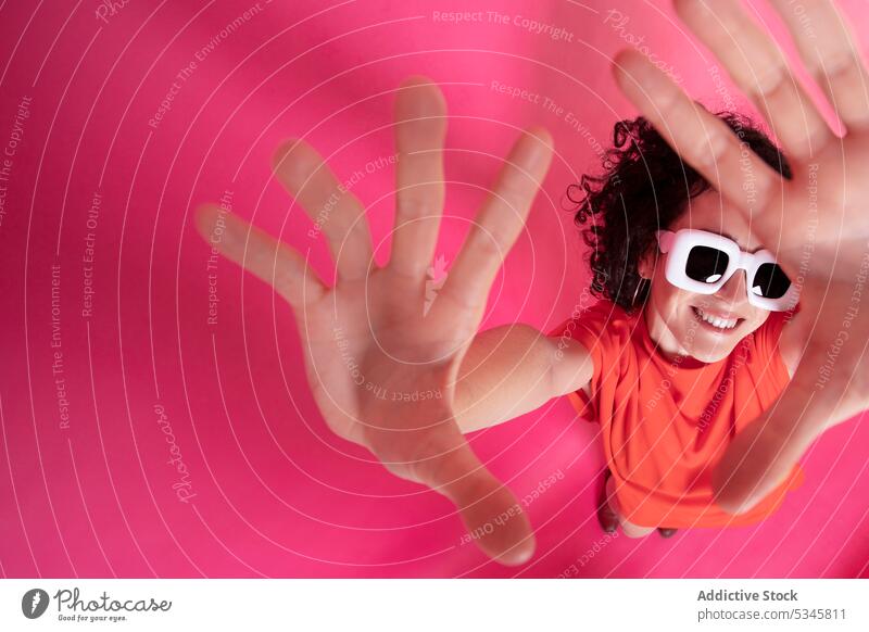 Lustige stilvolle Frau zeigt Palmen über rosa Hintergrund Handfläche Rahmengebärde Stil Sonnenbrille Lächeln Glück Zeichen heiter elegant positiv Symbol