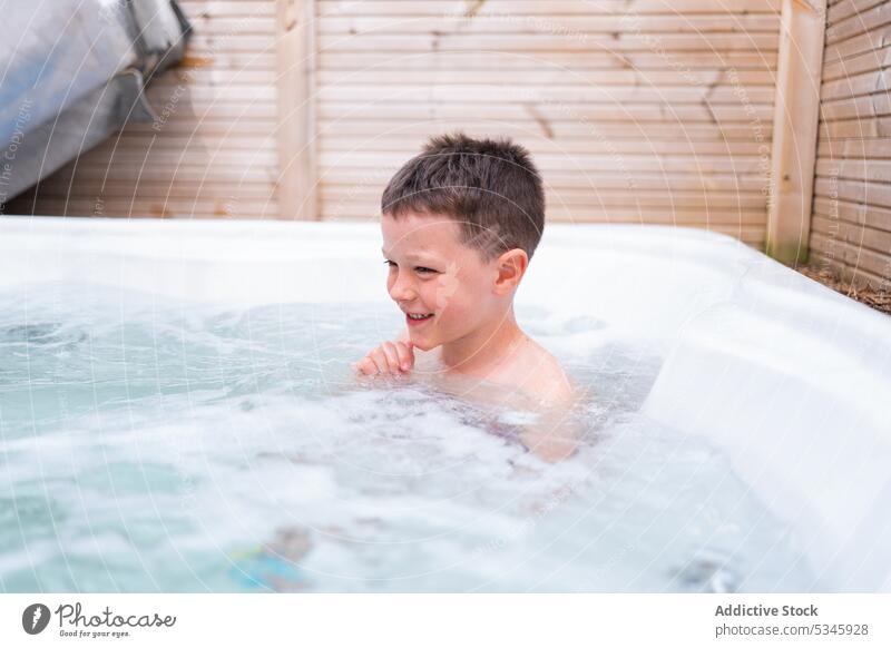 Kleiner Junge entspannt sich in einer heißen Badewanne im Badezimmer Lächeln Kübel genießen schäumen sich[Akk] entspannen Sommer Wochenende Erholung Kind