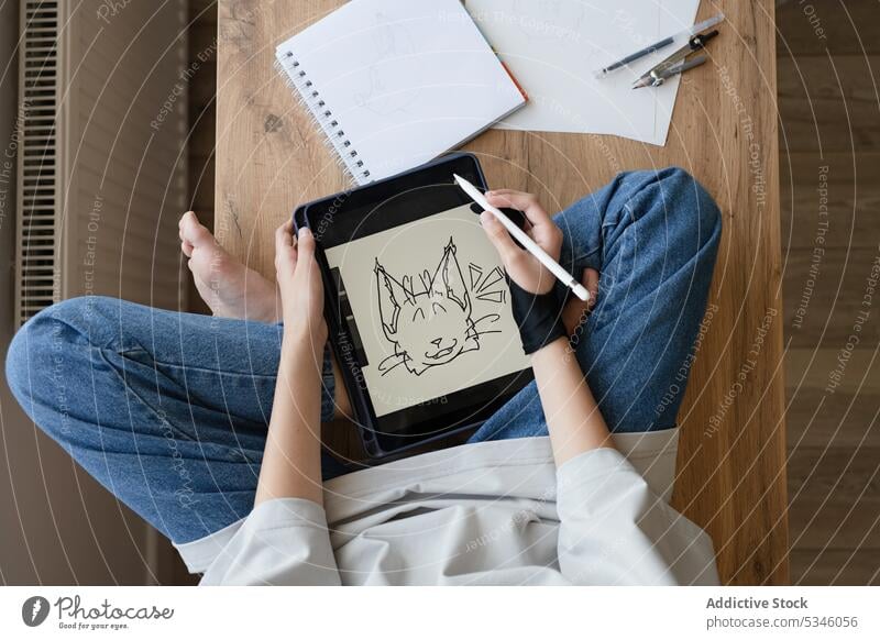 Crop anonyme Mädchen Zeichnung Tier auf Tablet sitzen auf dem Tisch zeichnen Tablette Künstler kreativ Skizze elektronisch digital Bildschirm Teenager Griffel
