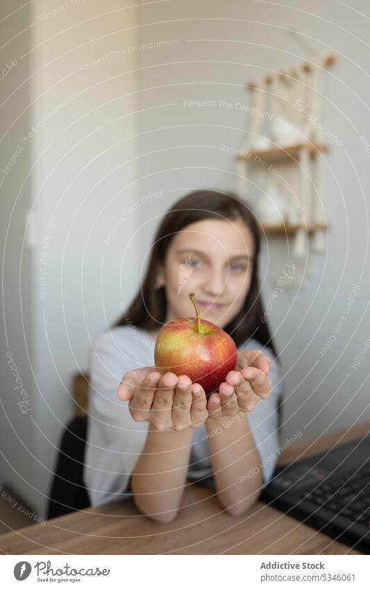 Mädchen mit Apfel am Arbeitstisch sitzend Snack positiv Teenager Bildung heimwärts Lächeln lernen Schreibtisch Arbeitsbereich lässig Jugendlicher Frucht