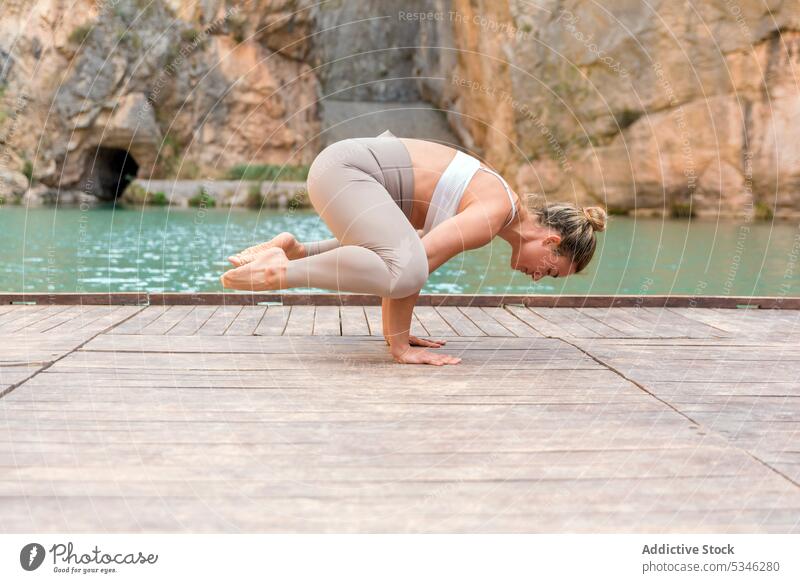 Flexible Frau in Kranich-Pose passen beweglich Yoga üben Asana Kranichpose Gleichgewicht Charco Azul Spanien Wellness Harmonie See Berge u. Gebirge Natur