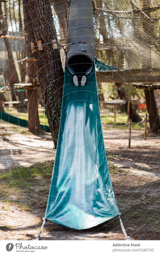 Anonymes Kind rutscht auf einem Spielplatz anonym Fuß Sliden Park ruhen Sommer unterhalten Seil Spaß haben Wochenende Kindheit Lügen Vergnügen sorgenfrei