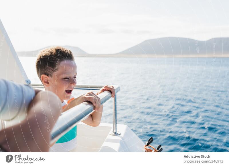 Lächelnder Junge auf Boot im Meerwasser MEER Wasser Schiff Schwimmer Kind Jacht Glück genießen Freude Urlaub frisch Sonnenlicht Vergnügen froh marin Resort