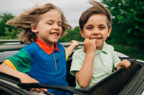 Adorable glückliche kleine Jungen Kinder in offenen Auto Schiebedach während der Reise PKW reisen Familie Menschen Fahrzeug jung sorgenfrei Freiheit Ausflug