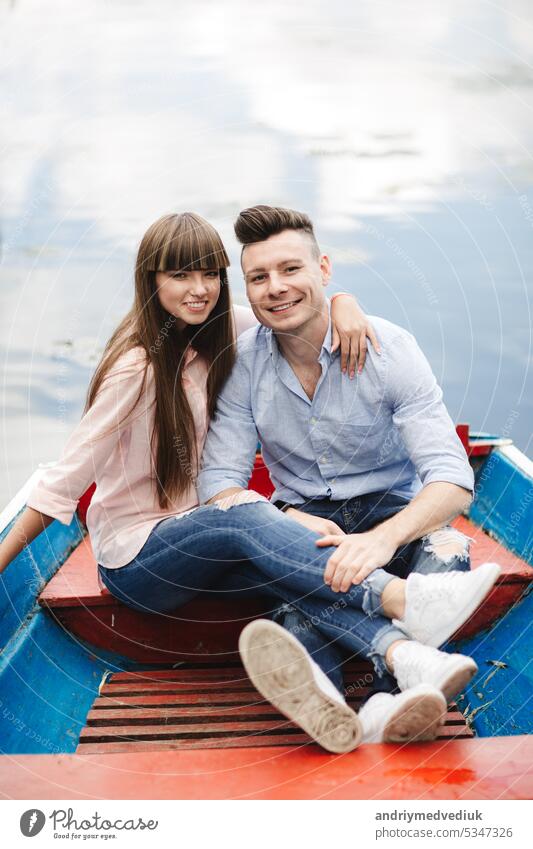 Ein Paar, das in einem blauen Boot auf einem See fährt. romantisch. emotionales Paar. lustig und verliebt jung Wasser Glück Sommer Romantik Fluss Urlaub Frau