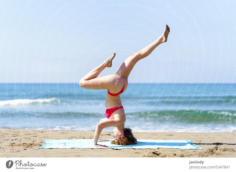 Flexible Frau im Bikini macht Yoga am Strand Dehnung Küste Meeresufer Gesundheit Natur Dreibein-Kopfstand MEER schlank Sonnenlicht Sommer schlanke hell üben