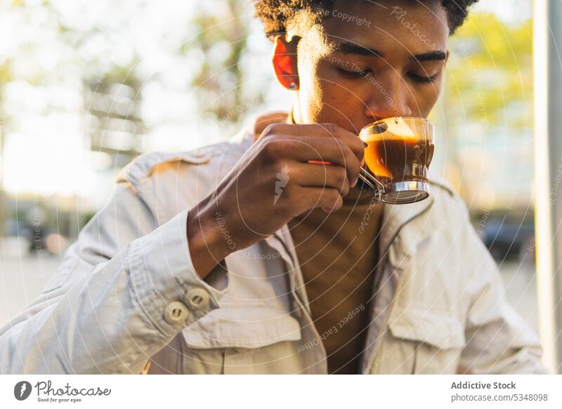Nachdenklicher schwarzer Mann trinkt heißen Espresso auf der Straße Kaffee besinnlich trinken nachdenklich Tasse Heißgetränk Afro-Look Getränk Afroamerikaner