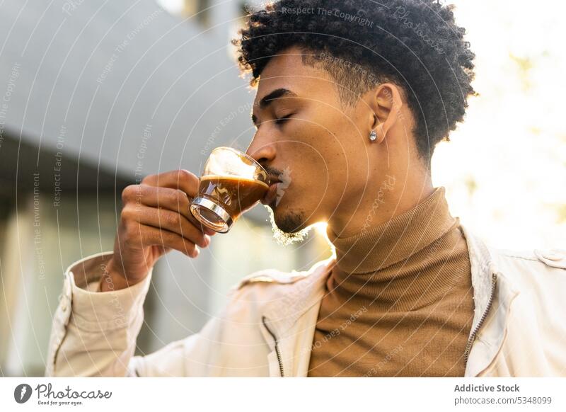 Nachdenklicher schwarzer Mann trinkt heißen Espresso auf der Straße Kaffee besinnlich trinken nachdenklich Tasse Heißgetränk Afro-Look Getränk Afroamerikaner
