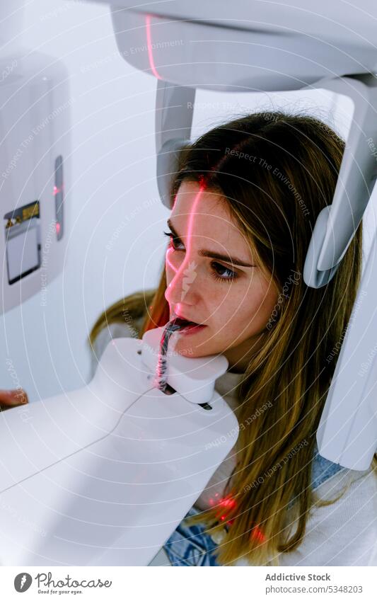 Junge Frau in zahnärztlichem Röntgen-Digitalscanner in heller Klinik lässig Röntgenbild Maschine dental digital Stomatologie Scanner Gerät Zahnmedizin benutzend
