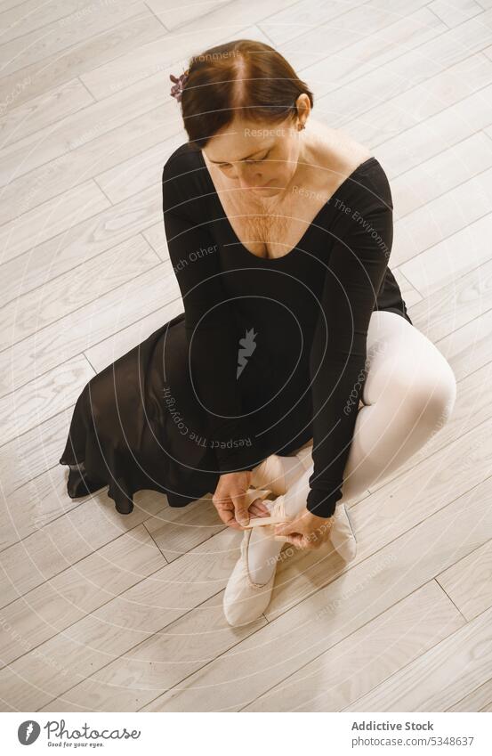 Ruhige Frau beim Anziehen von Ballett-Spitzenschuhen im Studio spitze Ballerina vorbereiten Balletttänzer Tänzer angezogen Atelier Fokus Choreographie Probe