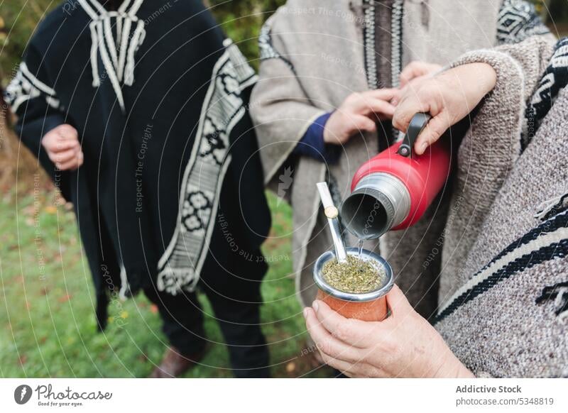 Ausgeschnittene Menschen in Wollponchos bei heißem Tee im Park Freund trinken Zusammensein Yerba Partnerin Heißgetränk sich[Akk] sammeln Zeit verbringen