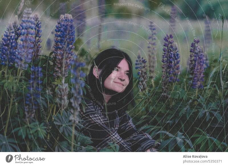 in einem Feld mit Lupinen III Blumen Blühend violett Natur purpur Nahaufnahme Lächeln dunkles Haar