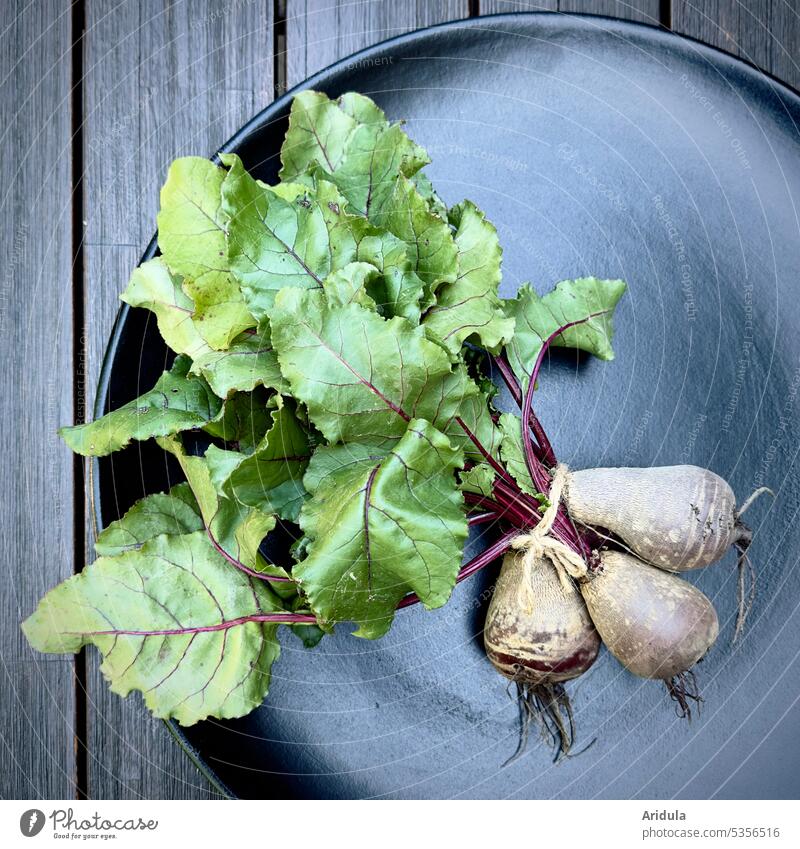 Gemüse | Bund Rote Beete liegt auf einem schwarzen Teller auf einem Holztisch Lebensmittel frisch Gesundheit Vegetarische Ernährung grün natürlich Vitamin Natur
