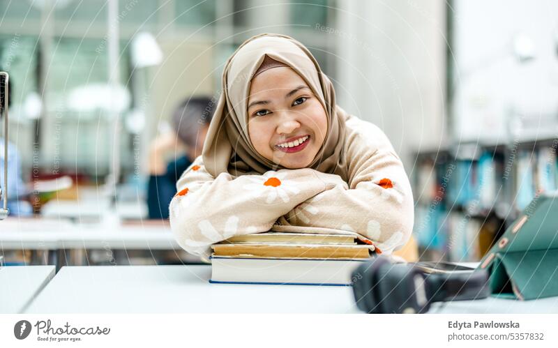 Porträt einer asiatischen muslimischen Studentin in einer Bibliothek echte Menschen Teenager Campus positiv Prüfung Wissen selbstbewusst schulisch Erwachsener