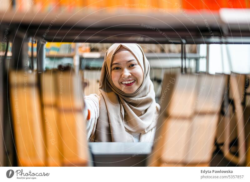Porträt einer asiatischen muslimischen Studentin, die in einer Bibliothek steht echte Menschen Teenager Campus positiv Prüfung Wissen selbstbewusst schulisch