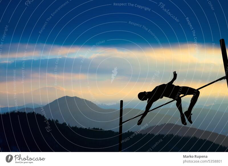 Silhouette eines Athleten beim Stabhochsprung in der Abenddämmerung Sieg Erfolg Leichtathletik Sportler springend Landschaft Berge Höhe Hintergrund Wolken Hügel