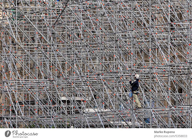 Ein Arbeiter auf einem Baugerüst bei der Arbeit an einem Gebäude Gerüst Inszenierung arbeiten Architektur Konstruktion Entwicklung Gerät Rahmen Wachstum