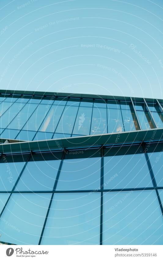 Glasfassade eines zeitgenössischen Firmengebäudes mit Himmel, Ansicht von unten. Wolkenkratzer Exterieur. Architektur Details. modern Gebäude Fassade Büro
