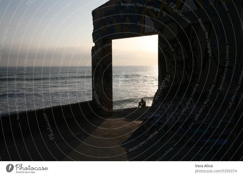 Mann sitzt am Meer verlassenes Gebäude Fenster Meerblick Fassade Vergänglichkeit Alleinsein