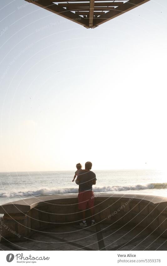 Vater und Tochter beobachten den Sonnenuntergang am Meer pazifik Kontemplation Nachmittag itim