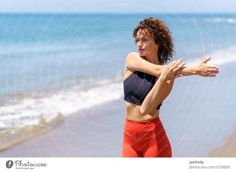 Verträumte Frau streckt sich am Meer Sportlerin verträumt besinnlich Dehnung Training Fitness Sportbekleidung MEER Aufwärmen Strand nachdenklich jung Wellness
