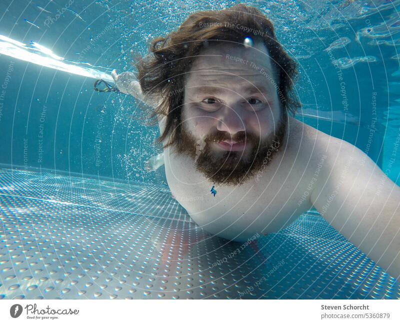 Mann taucht unter Wasser mit offenen Augen in einem Pool oder Schwimmbad Sommerferien Sommerurlaub Tauchen Schwimmen Schwimmen & Baden nass blau