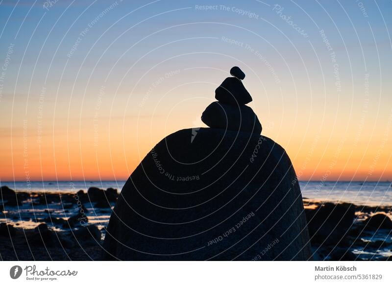 Steinpyramide an der Ostsee mit Blick auf das Meer bei Sonnenuntergang und blauer Stunde Pyramiden MEER baltisch Silhouette Steinhaufen Urlaub Himmel Küste