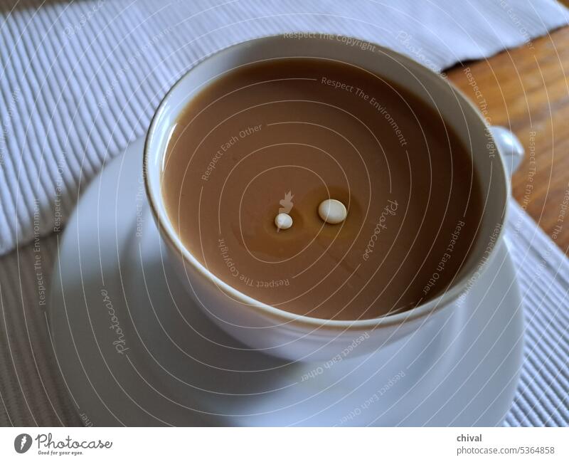 eine Tasse Kaffee mit Milchaugen rund Tisch Set