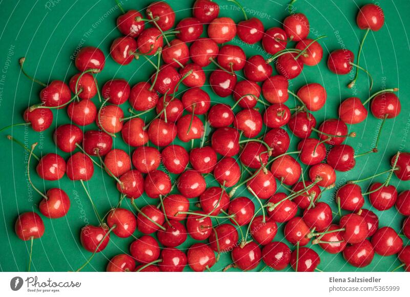 Rote Kirschen auf einem grünen Hintergrund Plakatwerbung Plakatwand natürlich Essen Vegane Ernährung kirschrot vitaminreich Foodfotografie Gesunde Ernährung