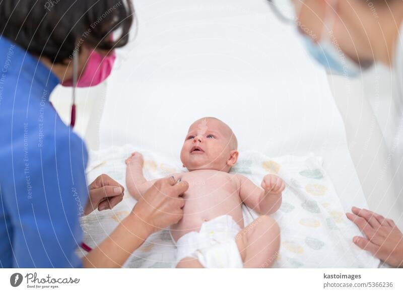 Ein Baby liegt auf dem Rücken, während sein Arzt es bei einer Standarduntersuchung untersucht Säugling Junge Kinderärztin Stethoskop Herzschlag Kindheit Medizin