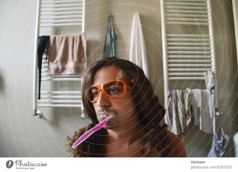 Foto einer Person im Badezimmer, die sich die Zähne putzt und mit einer flippigen Brille vom Tag träumt Mann schöne Menschen Morgenroutine gut aussehend Hygiene
