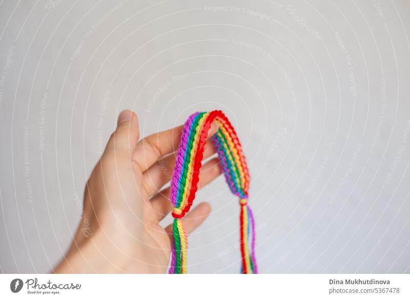 Hand hält Regenbogen häkeln handgemachte Armband. Feiern Stolz Monat mit Symbol Farben der lgbt abstrakt Kunst Hintergrund Business farbenfroh Konzept gemütlich
