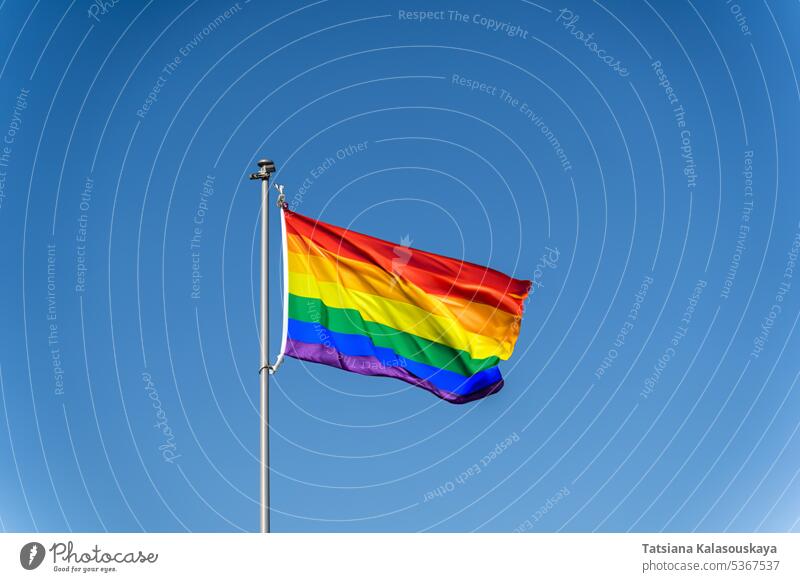 Die Regenbogenflagge der LGBTQ-Gemeinschaft weht vor blauem, klarem Himmel lgbtq winkend übersichtlich Blauer Himmel Stolz Gleichstellung Vielfalt Einschluss