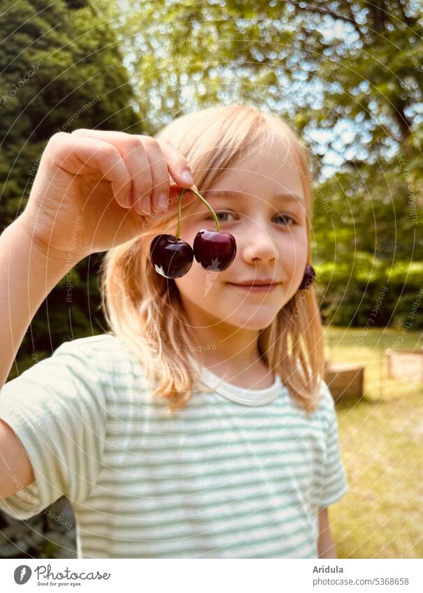 Kind hält zwei Kirschen in der Hand Sommer Ernte Frucht naschen Kindheit Freude rot reif Natur Garten Lebensmittel süß Lächeln Blick in die Kamera