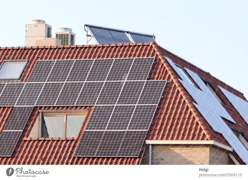 viele Solarmodule auf einem Dach Solarenergie Energie Energiegewinnung autark Haus Gebäude Fenster Schornstein Himmel schönes Wetter Erneuerbare Energie