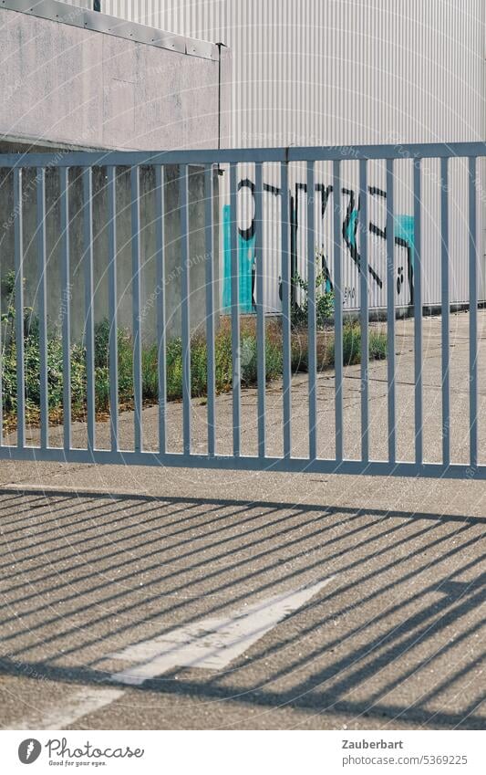 Geschlossenes Tor, Gewerbegebäude mit Graffiti, Schatten und Pfeil als Sinnbild für Hindernis, Problem oder Resignation geschlossen grau hellgrau Gewerbegebiet