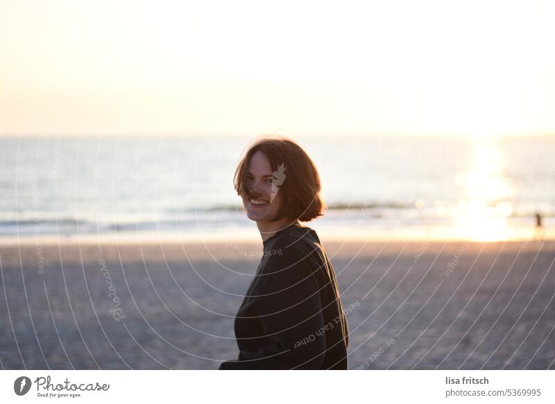 JUNG - FREI - FRÖHLICH Frau 30s Erwachsene attraktiv jung Außenaufnahme Lifestyle 20s Meer Strand Wind in den Haaren Sonnenlicht Sonnenstrahlen