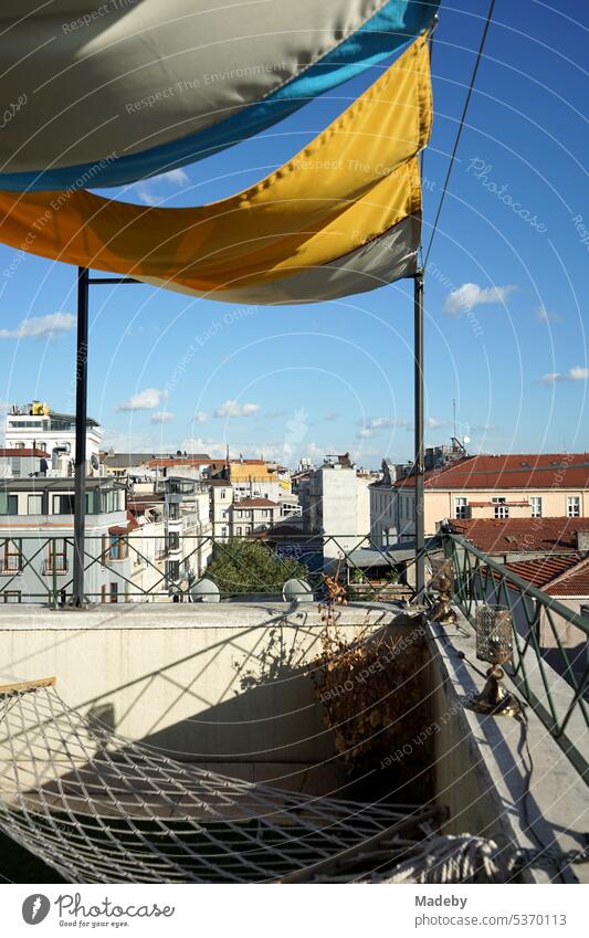 Alter Holzstuhl, Hängematte und grüner Kunstrasen auf der Dachterrasse eines Hotel im Stadtteil Taksim im Sommer bei Sonnenschein an der Istiklal Caddesi in Istanbul am Bosporus in der Türkei