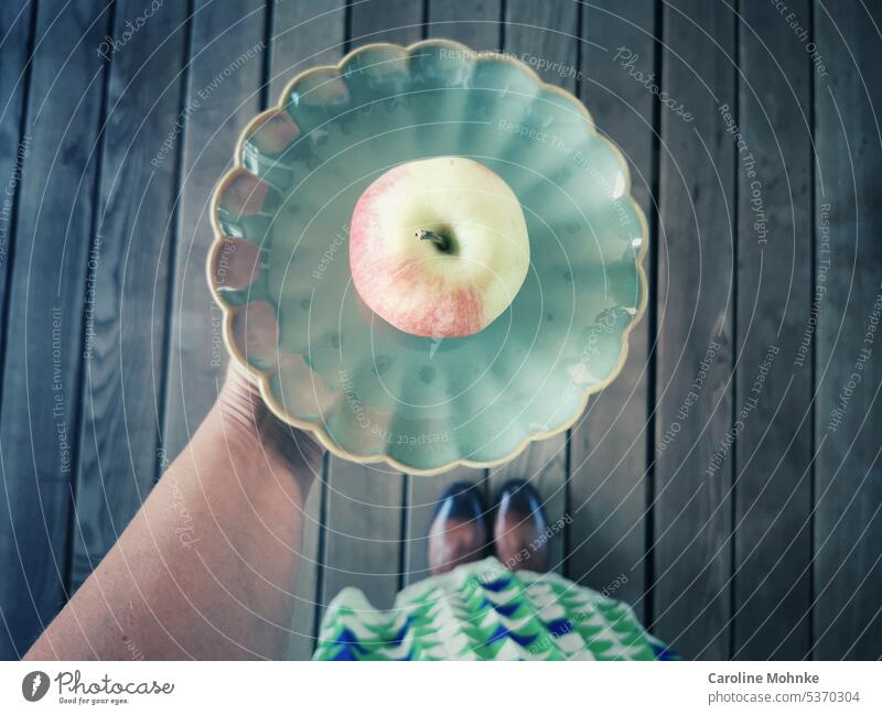 Frau hält einen grünen Teller mit einem Apfel in der Hand apfel Grün Kassiererin Ernährung Vitamine gesund Gesundheit Veganer Vegetarisch Gemüse Garten