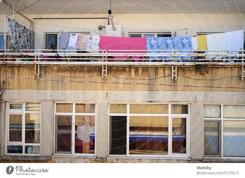 Wäscheleine mit bunten Wäschestücken auf dem Balkon eines alten Wohnhaus im Sommer bei Sonnenschein am Basar in Adapazari in der Provinz Sakarya in der Türkei