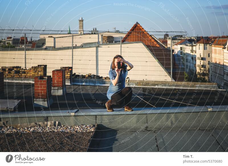 Junge Frau fotografiert auf dem Dach Fotografieren Berlin Prenzlauer Berg Stadt Außenaufnahme Hauptstadt Stadtzentrum Farbfoto Tag Altstadt Fotoapparat