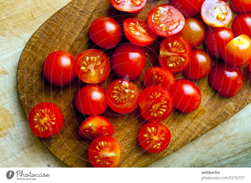 Kleine halbierte Tomaten ernährung essen frisch frucht gemüse gesund haushalt koch kochen küche mahlzeit nahrung obst schneidbrett schneidebrett schneiden