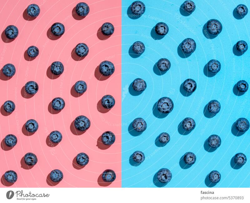 Heidelbeermuster auf rosa und blauem Hintergrund Blaubeeren Konzept flache Verlegung kreativ Superfood Draufsicht minimalistisch zwei Farben von oben nach unten