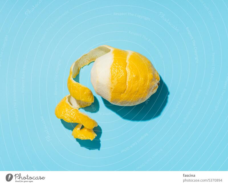 Zitrone und Spirale schälen auf blauem Hintergrund hardlight Zitronenschale Blauer Hintergrund minimalistisch hartes Licht sich[Akk] schälen Konzept Sommer