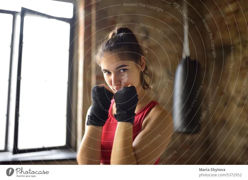 Junge Frau während eines Boxtrainings. Weiblicher Boxer beim Fitnesstraining. Regelmäßiger Sport stärkt das Immunsystem und fördert die Gesundheit und Widerstandsfähigkeit gegen Krankheiten.