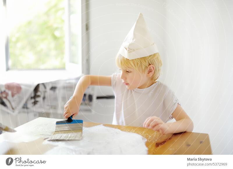 Kleiner Junge hat Spaß mit Pinsel bei der Reparatur von Zimmern. Kind hilft seinen Eltern beim Streichen von Möbeln. Farbe Bürste Tisch Raum flach Appartement