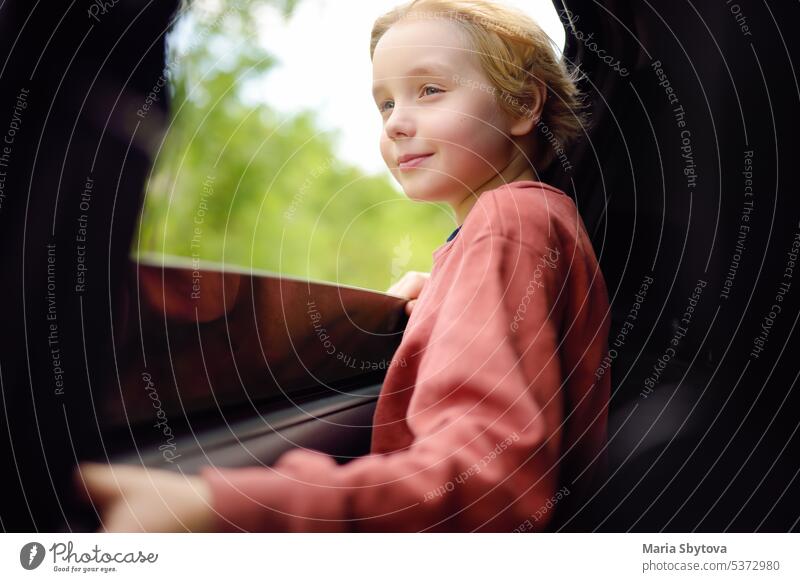 Cute preteen Junge Blick durch das Fenster des Autos während der Familie Road Trip und genießen Sie die angenehme Erwartung der glücklichen Urlaub. Joyful Kind reisen mit Eltern während der Ferien.