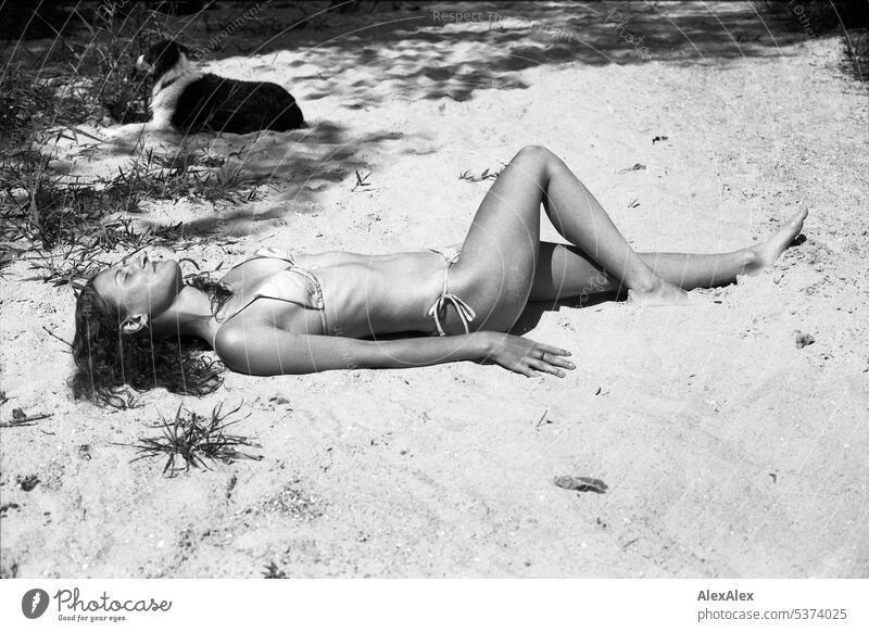 analoges, schwarzweißes, seitliches Ganzkörper- Portrait einer jungen, schönen Frau am Strand warm sommerlich schönes wetter Sommer Tag Selbstbewußt
