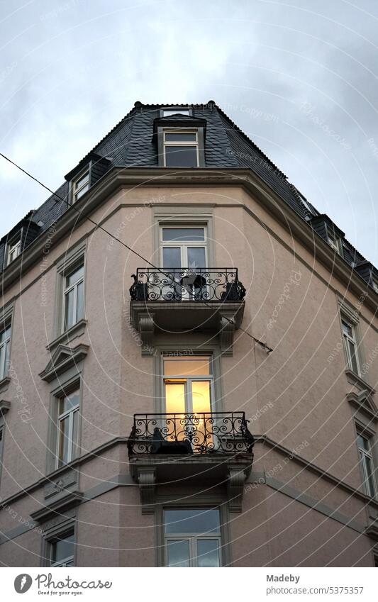 Licht hinter dem Fenster eines alten Eckhaus mit schönem Balkon und Licht im Wohnzimmer am Abend im Stadtteil Bornheim in Frankfurt am Main in Hessen frankfurt